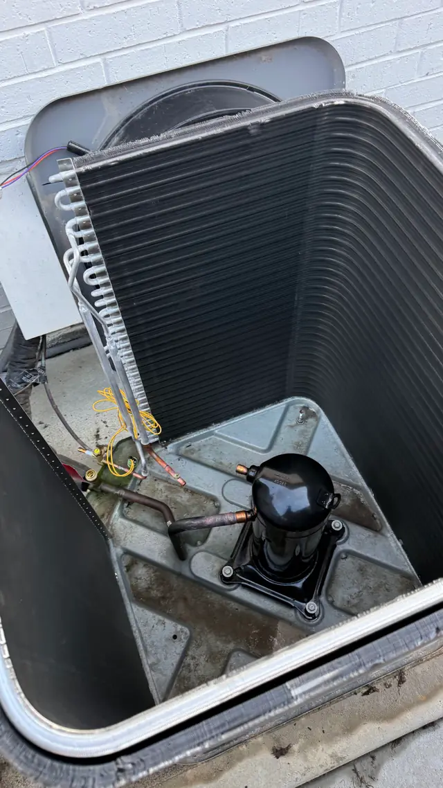 Condenser unit opened up with the compressor and coil exposed during a Prime Texas Air service call